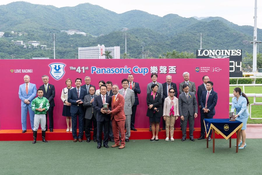 信興集團主席兼行政總裁蒙德揚博士（右）將獎盃頒予「堅又威」的練馬師姚本輝（左）。